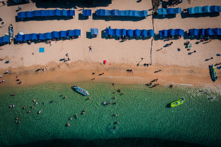 Foto desde arriba de Playa Blanca, arena blanca, aguas cristalinas y carpas azules